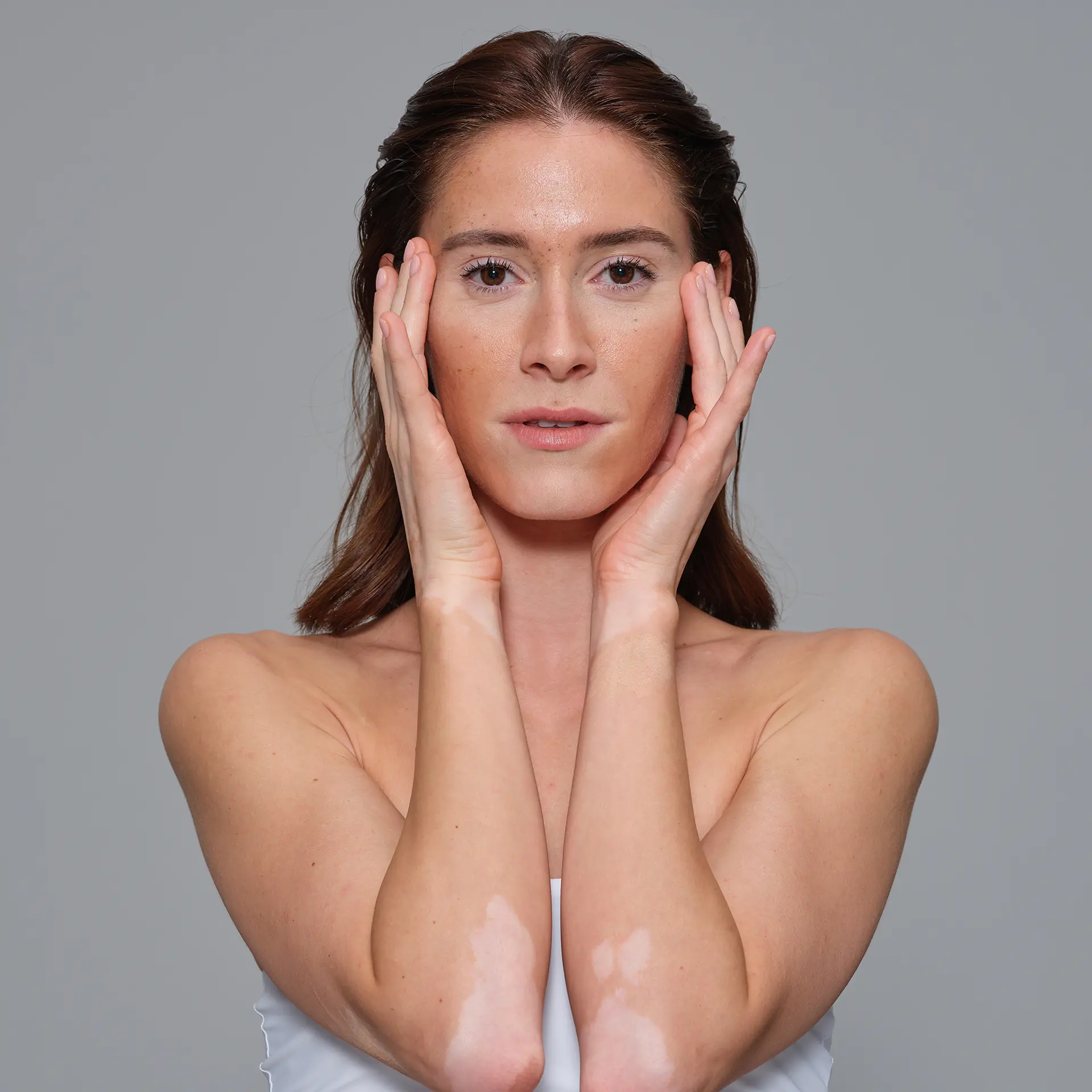 Model touching her face.