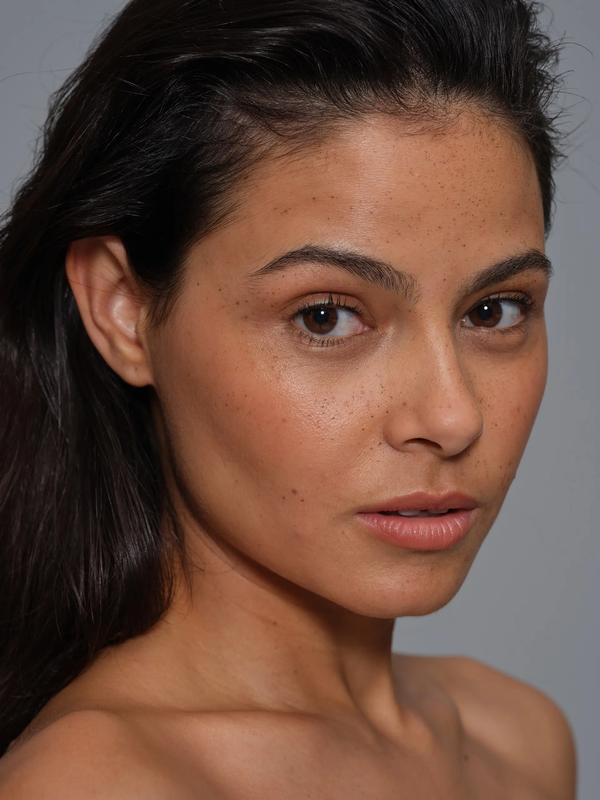 Portrait shot of an female model in front of a light grey background.