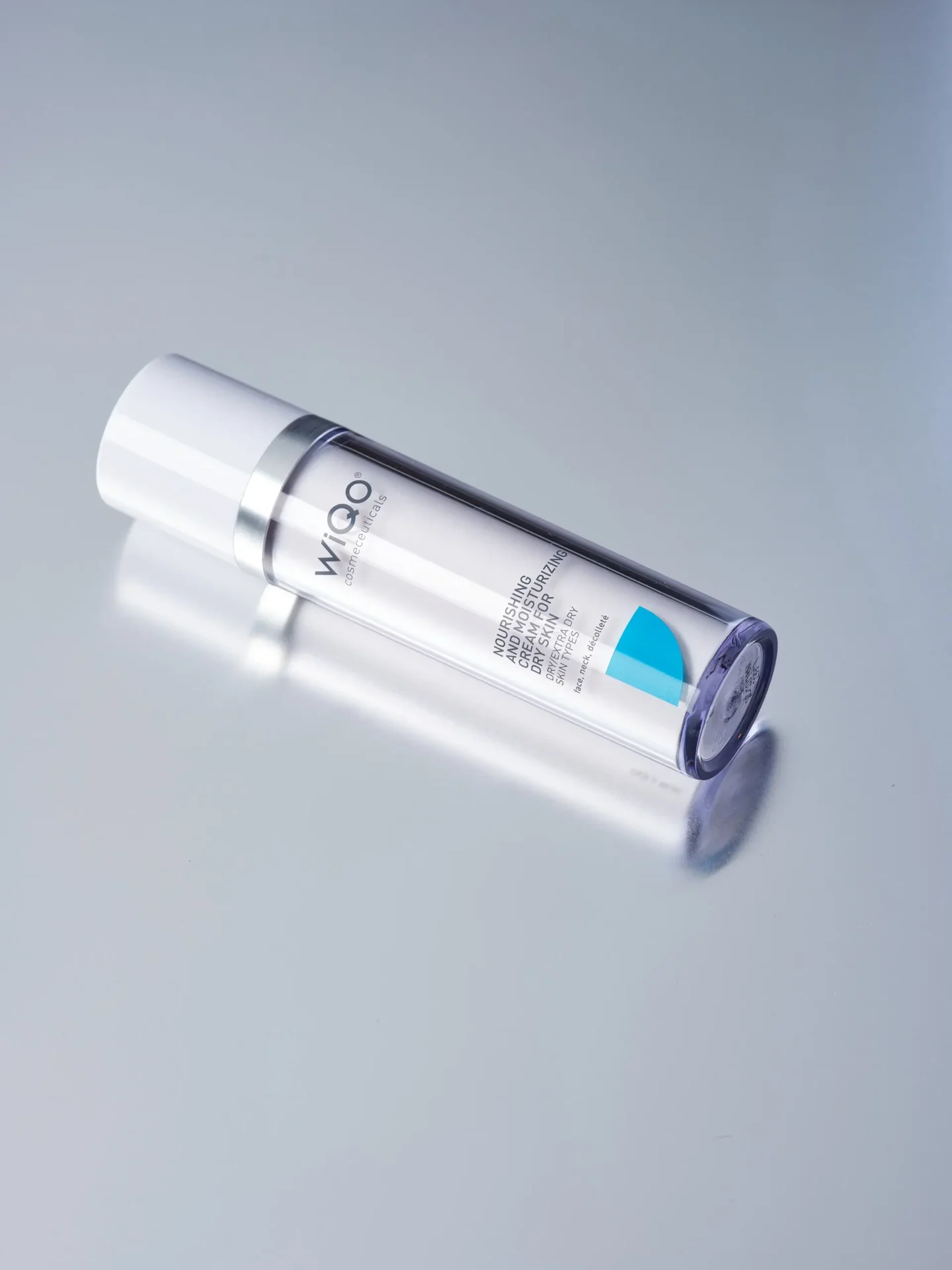 Product image of the WiQo Nourishing Cream for dry skin lying on a light grey surface with slight rotation.