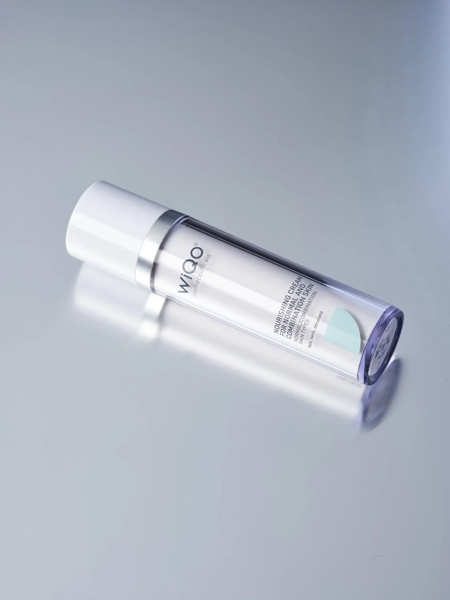 Product image of the WiQo Nourishing Cream for normal and combination skin lying on a light grey surface with slight rotation.