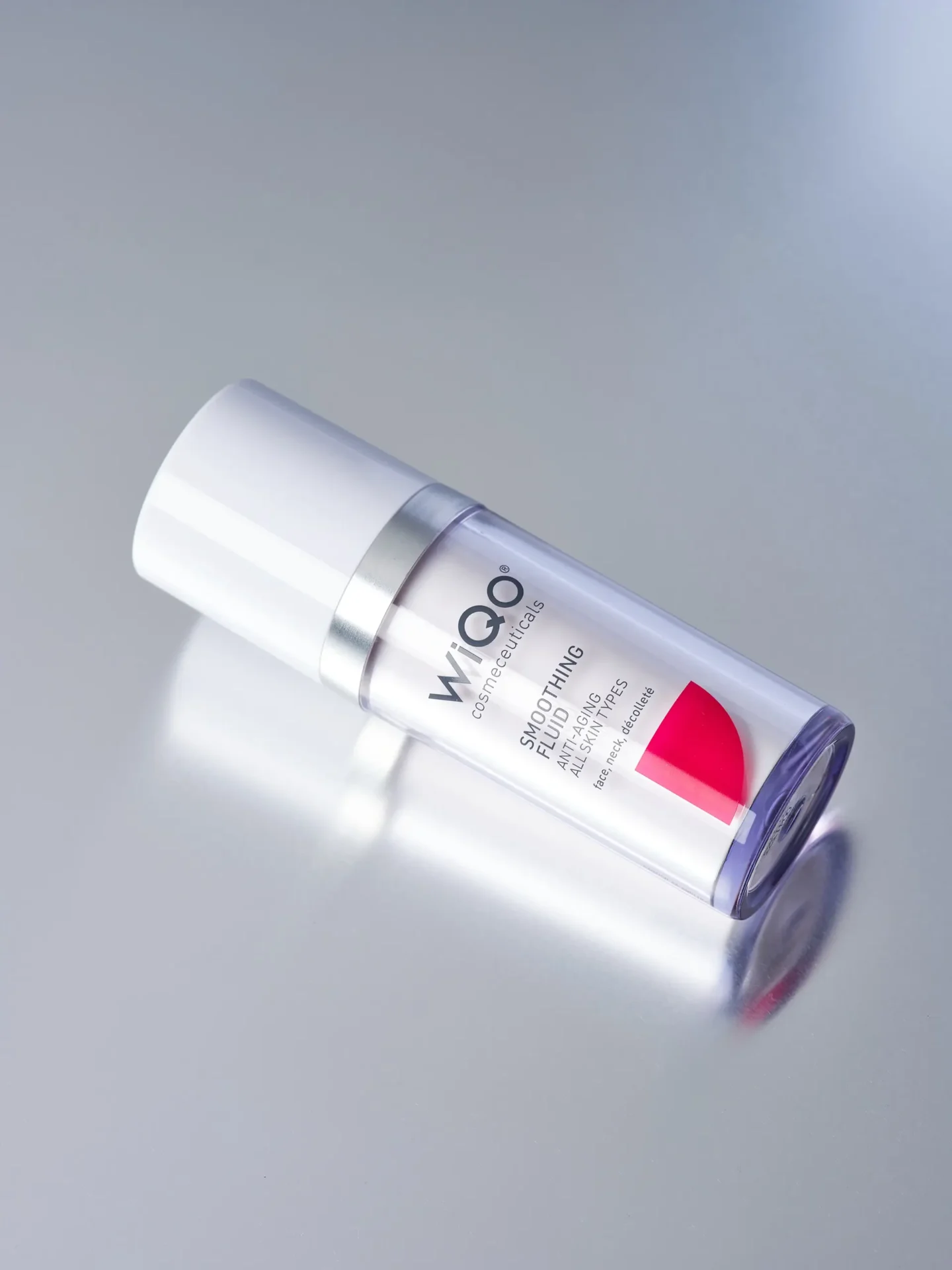 Product image of the WiQo Smoothing Fluid lying on a light grey surface with slight rotation.