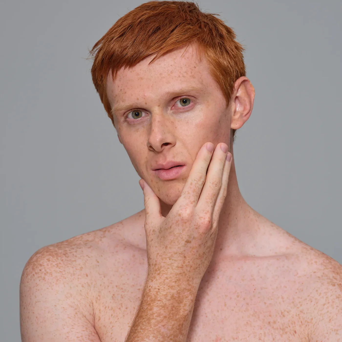 Redhead male model touching his face
